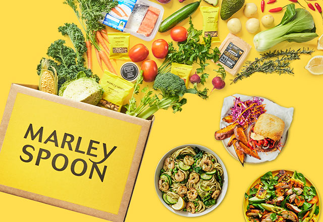 Family with a Marley Spoon meal kit filled with fresh ingredients and 3 cooked dishes